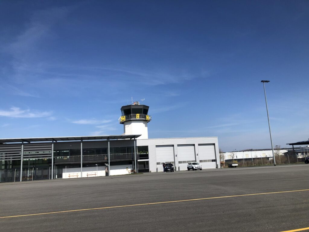 Terminal und Tower am Flugplatz Chemnitz-Jahnsdorf unter blauem Himmel