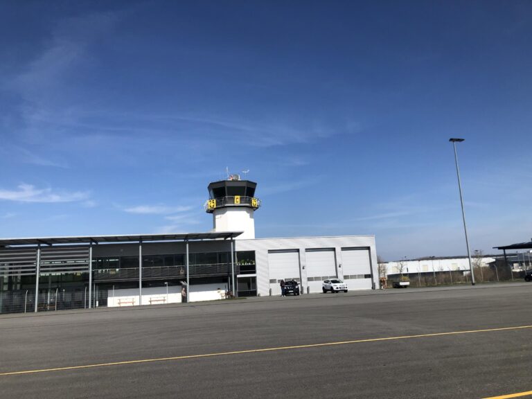 Terminal und Tower am Flugplatz Chemnitz-Jahnsdorf unter blauem Himmel