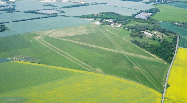 Luftaufnahme des grünen Flugplatzes Taucha mit Graspiste und angrenzenden Feldern